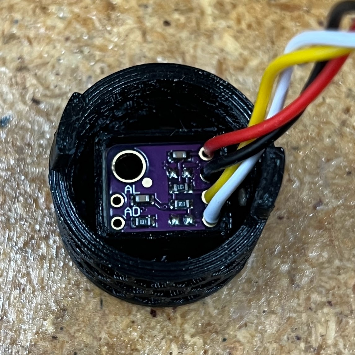 Close-up field photo of a wired SHT30 sensor daughterboard installed in a ventilated holder away from the product mainboard