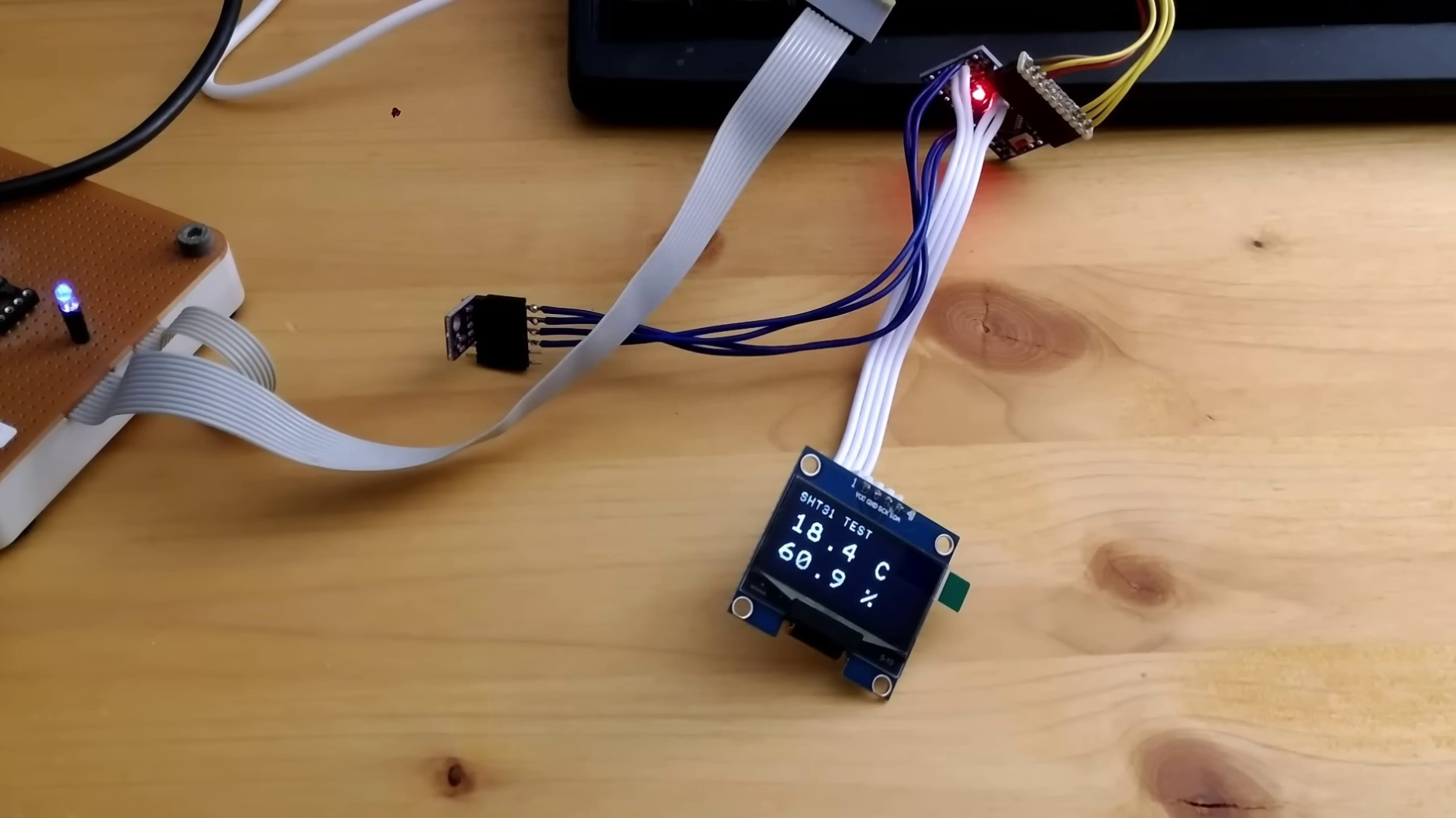 Real SHT31 bench test showing 18.4 degrees Celsius and 50.9 percent humidity on an OLED